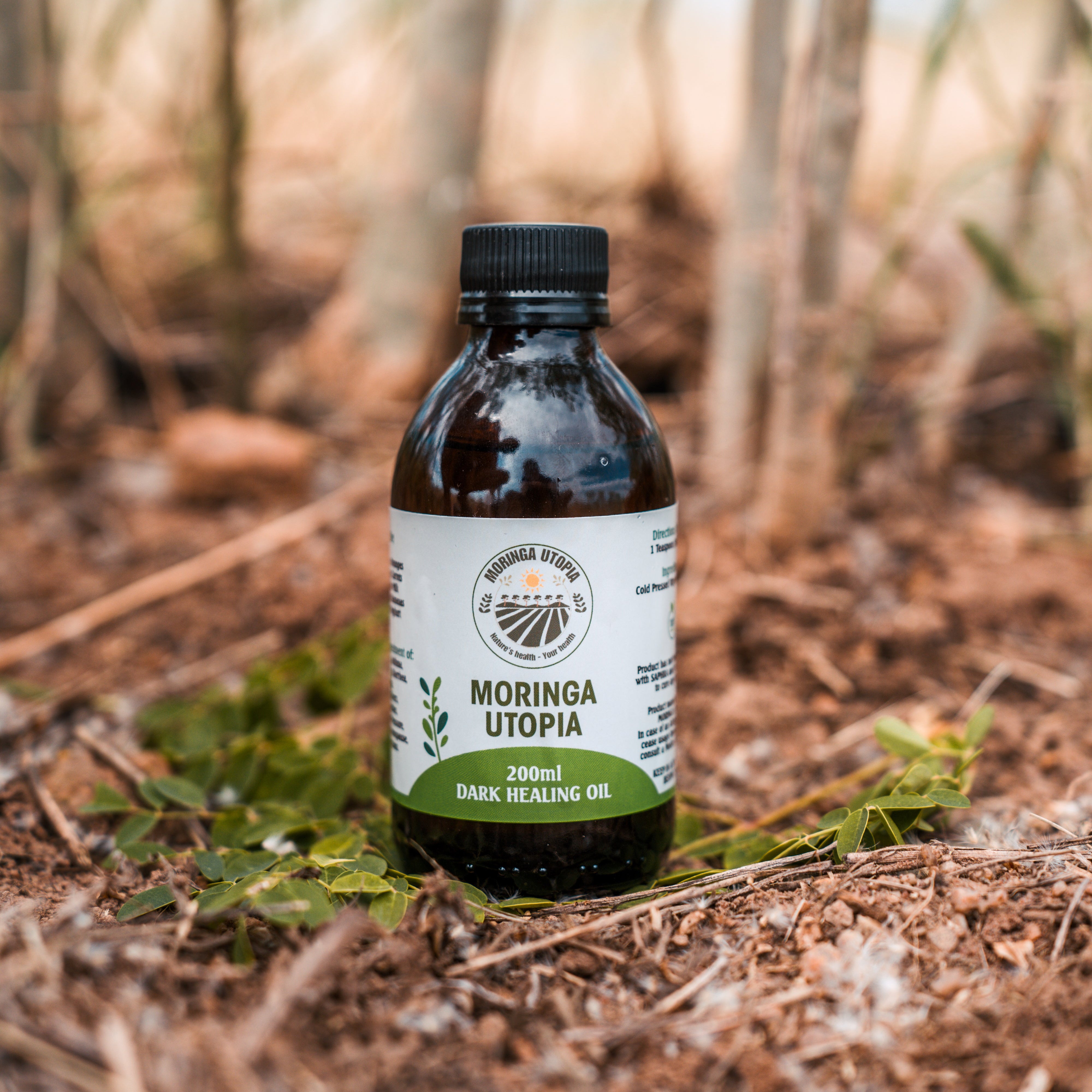 Bottle of Moringa Utopia oil in a forest setting