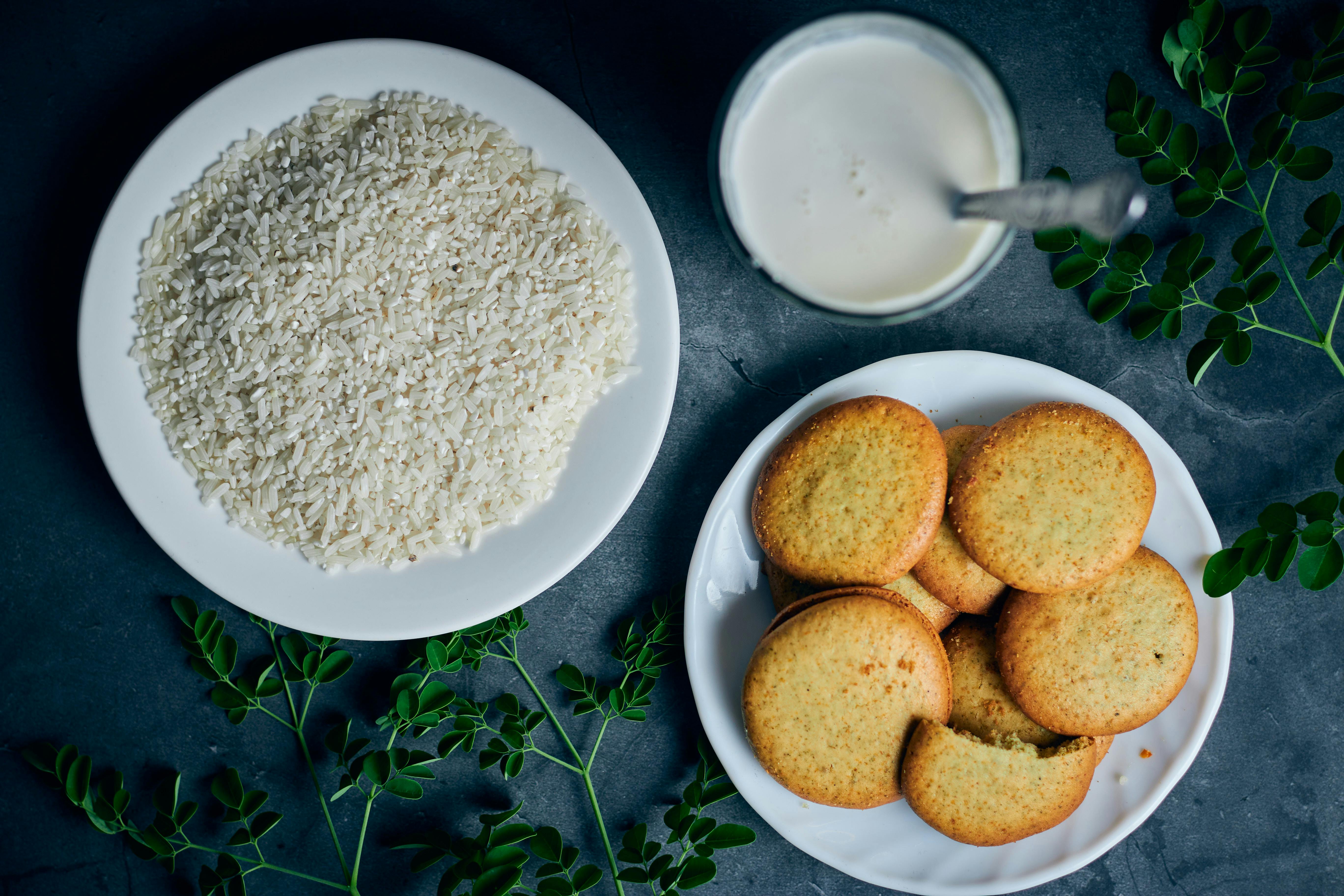 Aerial view of rice, cookies, and Moringa leaves on plates in a Bicol, Philippines kitchen.